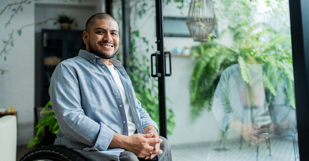 An image of a disabled U.S. Veteran smiling and sitting in his healthcare provider’s office