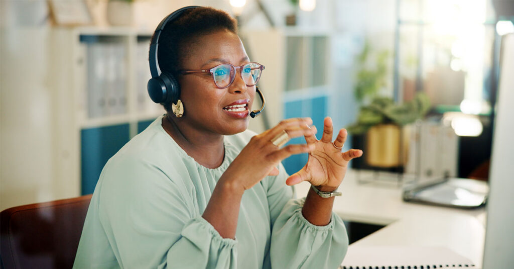 Image depicting a female helpline operator describing the application process to a caller over the phone